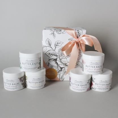 size petite butter balms in white plastic jars with floral labels and a beautifully wrapped package with pink ribbon