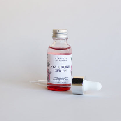Red Hyaluronic Serum bottle on a minimal bakground.