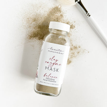Clay enzyme mask with a brush and powder on a white background