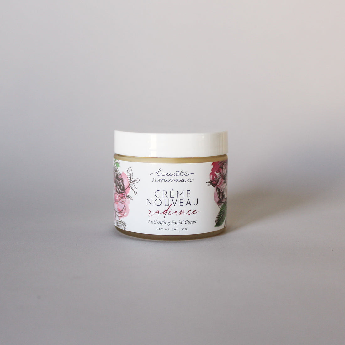 A jar of Crème Nouveau anti-aging face cream for dry, mature skin on  a light background.