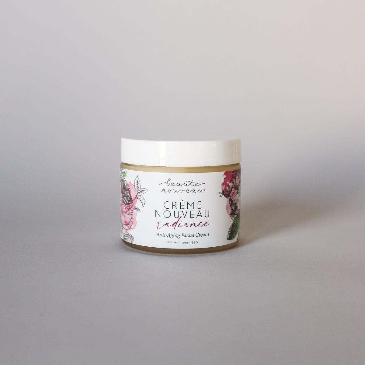 A jar of Crème Nouveau anti-aging face cream for dry, mature skin on  a light background.